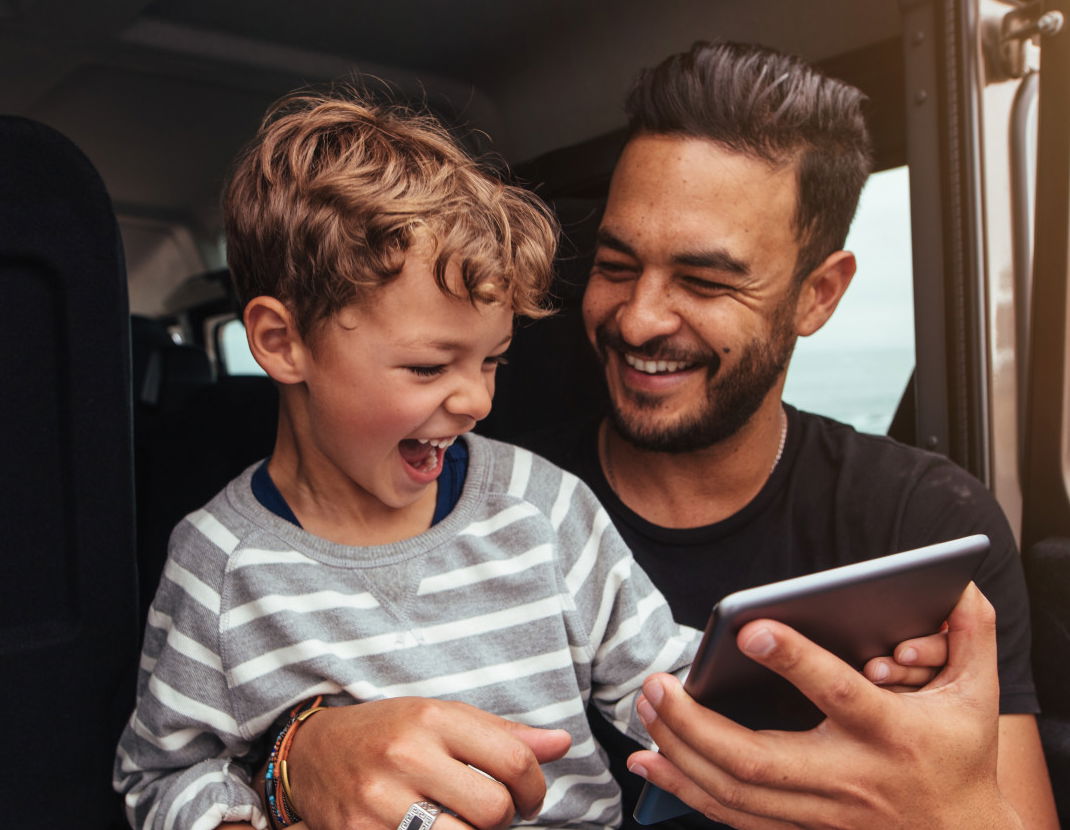 Father and son enjoying reading an ebook together on a tablet or ipad
